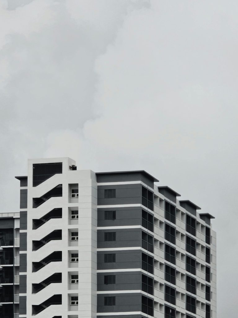 an airplane flying over a tall building in a cloudy sky